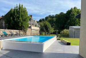 a swimming pool in a yard with chairs around it at La Villa Cosy in Espalion