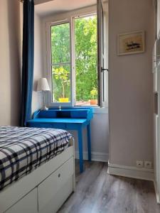 um quarto com um lavatório azul e uma janela em Appartement entier - Paris 12 em Paris