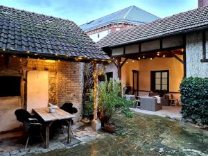 a patio with a table and chairs in a house at Maison Marcks Champagne in Ay