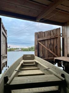 un barco sentado en el agua con una puerta de madera en Laivu māja uz Alūksnes ezera/ Boat house on a Lake en Alūksne