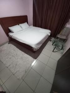 a bedroom with a bed and a chair and a table at Nakuru Lovely 2bedroom Master ensuite in Nakuru