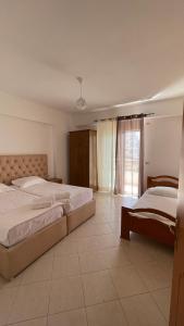 a bedroom with two beds and a window at Overview Apartments Saranda in Sarandë