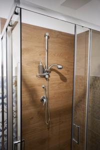 a shower in a bathroom with a wooden door at INCASTRO B&B IN CROTONE in Crotone