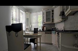 a kitchen with white cabinets and a table and chairs at Willa Aqua -parking included in the price in Świnoujście