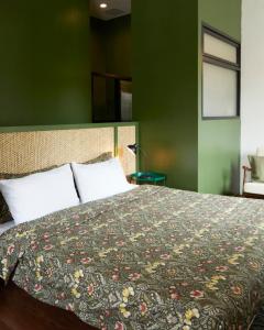 a bedroom with a bed with a floral bedspread at Motu Bangkok in Bangkok