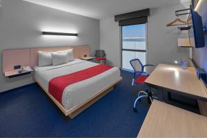 a hotel room with a bed and a desk and a desk at City Express by Marriott CDMX Plaza Central in Mexico City