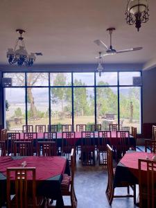 a dining room with tables and chairs and a large window at Rock City Resort in Mingora