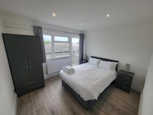a bedroom with a large bed and a window at Bright Modern 3 Bedroom Apartment in Sutton