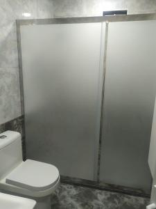 a bathroom with a toilet and a glass shower door at House in Nakhchivan city, Azerbaijan in Naxçıvan