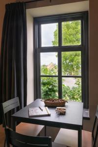 Una mesa frente a una ventana con una cesta. en Landelijke boerderijkamer, dichtbij Kinderdijk en Oud-Alblas