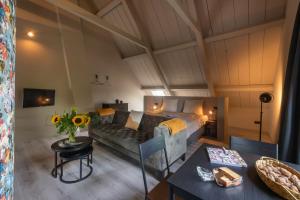 a room with a bed and a couch and a table at Landelijke boerderijkamer, dichtbij Kinderdijk in Oud-Alblas