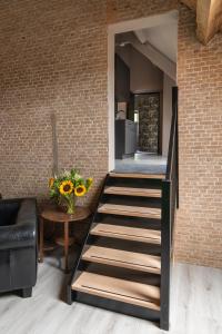 a staircase in a living room with a brick wall at Landelijke boerderijkamer, dichtbij Kinderdijk in Oud-Alblas