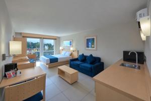 Habitación de hotel con cama y sofá azul en City Express by Marriott Xalapa en Xalapa