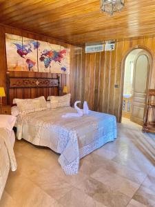 Un dormitorio con una cama con un cisne. en Magnífico Castillo privado, elevado en la roca en La Cabrera