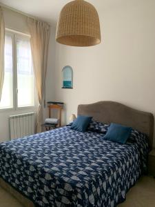 een slaapkamer met een bed met een blauw dekbed bij Aria di mare in Sanremo