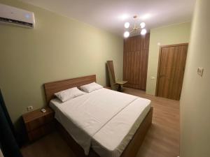 a bedroom with a large bed with white sheets at Dani Apartment in Kutaisi