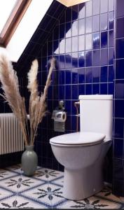 La salle de bains est pourvue de toilettes et d'un mur carrelé bleu. dans l'établissement Maison Marcks Champagne, à Ay