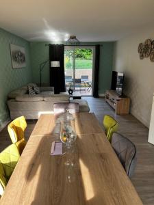 a living room with a wooden table and a couch at Belle maison familiale proche du lac in Bourges