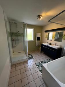 uma casa de banho com um chuveiro, uma banheira e um lavatório. em Belle maison familiale proche du lac em Bourges