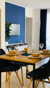 einen Esstisch mit Stühlen und eine blaue Wand in der Unterkunft Classy Villány in Villány