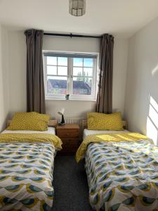 1 Schlafzimmer mit 2 Betten und einem Fenster in der Unterkunft Chessington Home Stay , 3 Bed 6 Guests Free Parking Near M25 JCT9, Chessington world of Adv Resort, Kingston, Epsom, Great for Families & Groups in Chessington