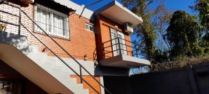 un edificio in mattoni con balcone sul lato di Martina Apart a Puerto Iguazú