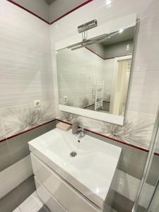 a white bathroom with a sink and a mirror at RentNow Family Large Apartament near Airport in Chişinău +22 photos
