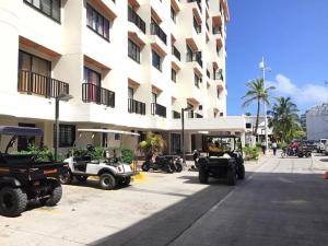 eine Gruppe von Fahrzeugen, die vor einem Gebäude geparkt sind in der Unterkunft Villa del mar apartaestudio in San Andrés