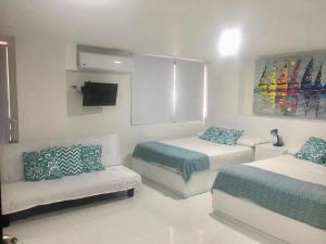 ein Wohnzimmer mit 2 Betten und einem Sofa in der Unterkunft Villa del mar apartaestudio in San Andrés