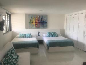 ein Schlafzimmer mit 2 Betten und einem Wandgemälde in der Unterkunft Villa del mar apartaestudio in San Andrés