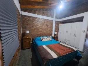 a bedroom with a bed and a brick wall at Mendoza Urbano Confort in Mendoza