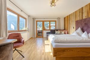 um quarto de hotel com duas camas e uma mesa e cadeiras em Appartements SonnAlm em Berwang