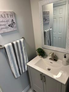 uma casa de banho com um lavatório e um espelho em Luxurious and modern one bedroom basement suite. em Brampton
