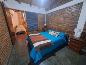 a bedroom with a bed and a brick wall at Mendoza Urbano Confort in Mendoza