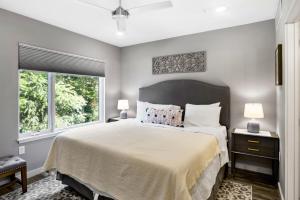 a bedroom with a large bed and two windows at South Slope Townhome with Private Elevator Unit 102 in Asheville