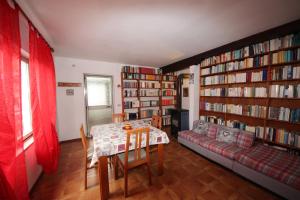 uma sala de estar com uma mesa, um sofá e livros em Albergo Diffuso Costauta em Costalta