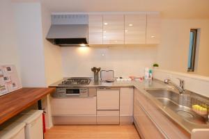 a kitchen with white cabinets and a sink at Seirai Vacation Rental Hatsudai - Vacation STAY 15951v in Tokyo