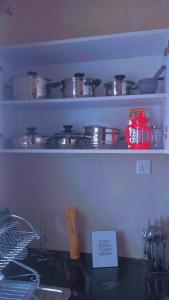 a kitchen counter with pots and pans on shelves at Kathy's Place in Runda in Nairobi
