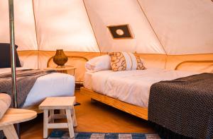 1 dormitorio con 2 camas en una tienda de campaña en Terranova Glamping en Luján