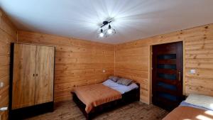 1 dormitorio con 1 cama y ventilador de techo en Domek gdzieś na końcu świata, en Bandrów Narodowy