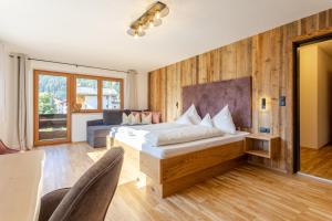 ein Schlafzimmer mit einem Bett in einem Zimmer mit Holzwänden in der Unterkunft Appartements SonnAlm in Berwang