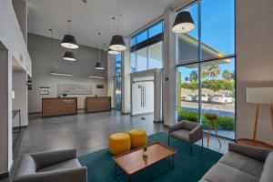 - un hall de bureau avec des chaises, des tables et de grandes fenêtres dans l'établissement City Express by Marriott Los Mochis, à Los Mochis