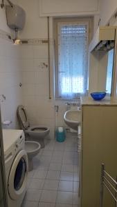 a bathroom with a toilet sink and a washing machine at Margin - Appartamento vicino al centro in Genoa