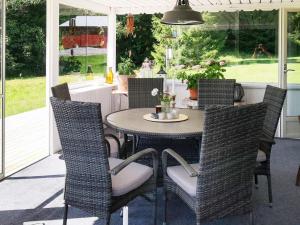 an outdoor dining room with a table and chairs at Holiday home Gunnarskog II in Gunnarskog