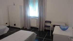 a room with a bed and a table and a window at Margin - Appartamento vicino al centro in Genoa