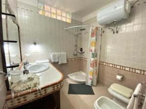 都拉斯The White Corner的带两个水槽、一个马桶和一个淋浴的浴室