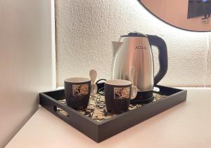 a tea kettle and two cups on a tray at The White Corner in Durrës
