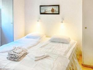 ein weißes Bett mit weißer Bettwäsche und Handtüchern darauf in der Unterkunft Holiday home DALARÖ II in Dalarö