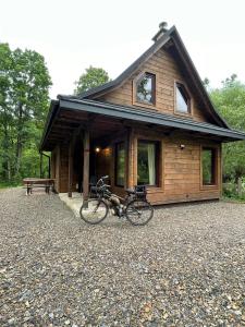 a bike parked in front of a log cabin at Villejka, domki i domy wakacyjne in Wetlina