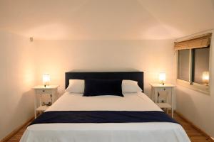 een slaapkamer met een groot bed met 2 nachtkastjes bij The View Penthouse Apartment in Jeruzalem